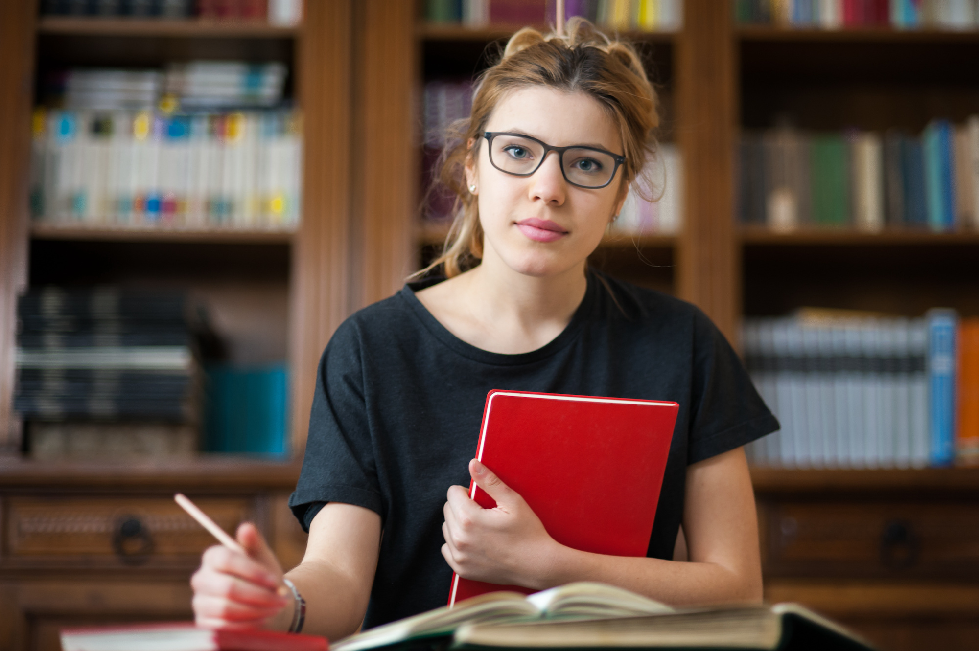 Female student in a library with book in hands